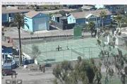 Webcam of Jerry in front of bench at tennis court